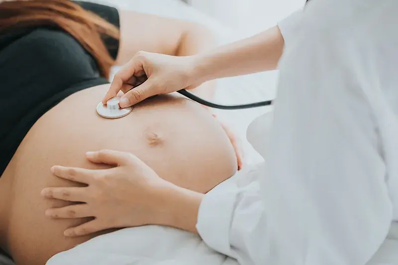 doctor listening to pregnant belly